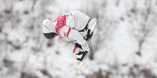 Kyle Mack competes at  PyeongChang 2018, grabbing his board as he flies through the air. 