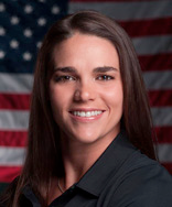 Headshot of Emily in front of an American flag