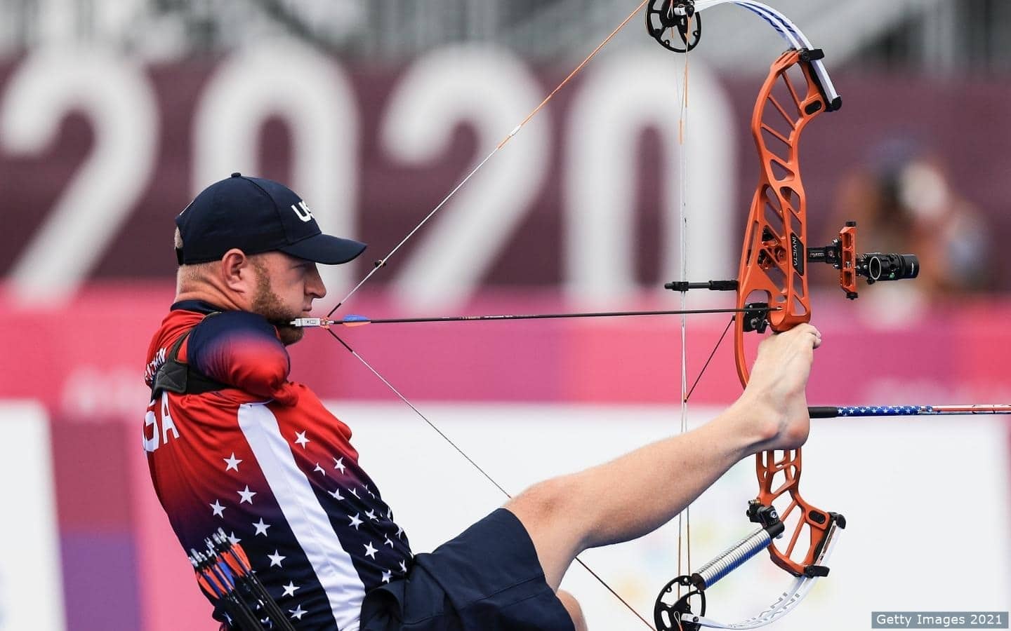U.S. Paralympic Archer stabilizes both with is mouth and lips in preparation to take a shot.