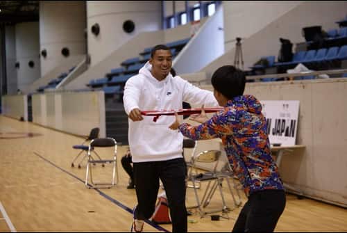 Michael Norman learns how to pass the Tasuki (baton) for the Hakone Ekiden race from a Chuo University student.