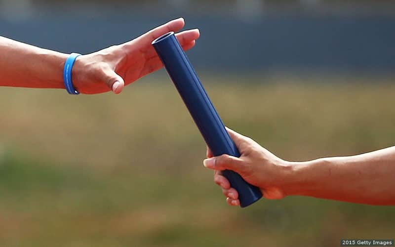 A detail view of the baton changing hands.
