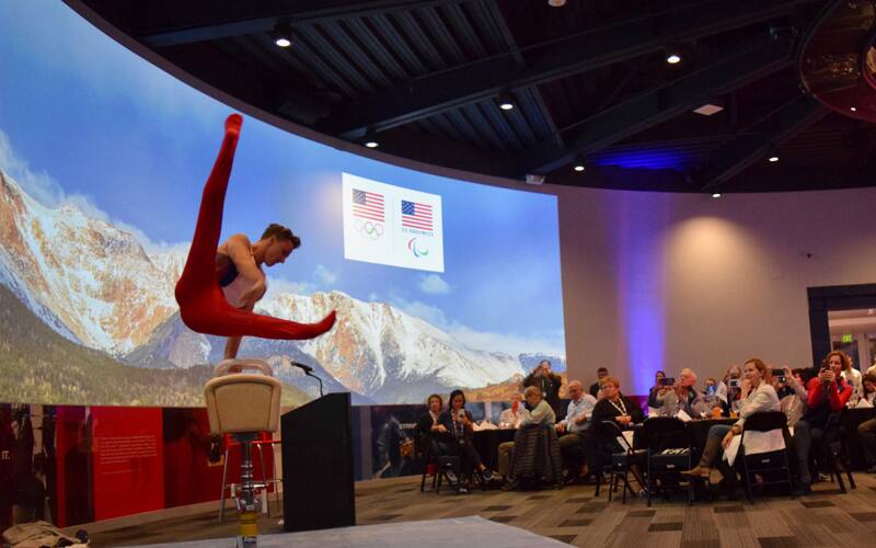 Gymnast Eddie Penev demonstrates a pommel horse routine in front of guests at the Olympic Training Center on Oct. 20, 2017.