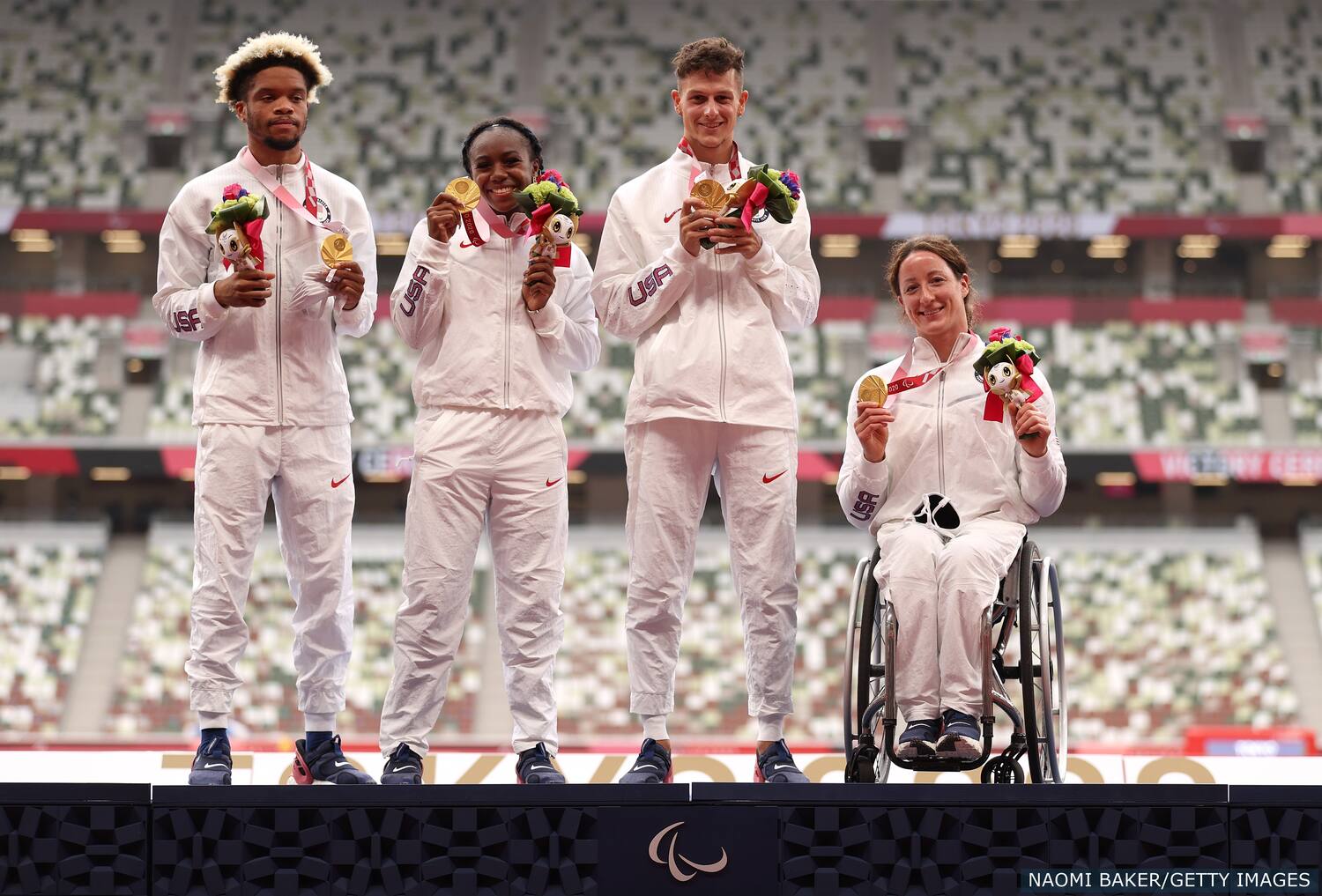 Noah Malone Brittni Mason Nick Mayhugh and Tatyana McFadden celebrate winning gold in the 4x100 meter universal relay for Team USA at the Tokyo Paralympics