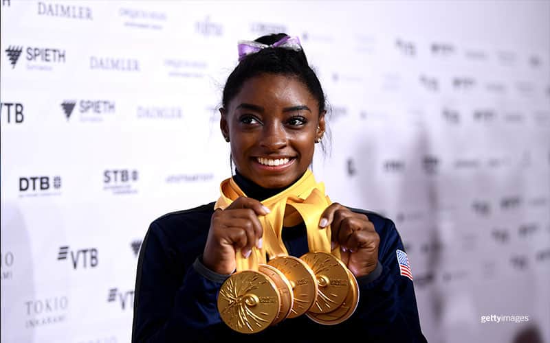Simone Biles poses for photos with her multiple gold medals during day 10 of the 49th FIG Artistic Gymnastics World Championships in Stuttgart, Germany.