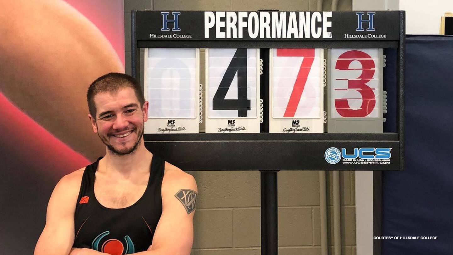 Justin Caine poses with his results at a Hillsdale College event. 