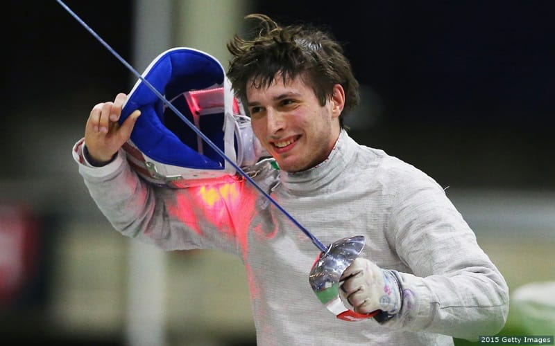 U.S. fencer Eli Deshwitz removes his mask and smiles after competing. 
