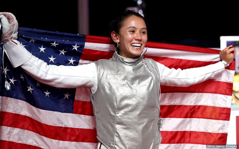 U.S. fencer Lee Kiefer holds the American flag up as she celebrates winning gold in the women's foil at the 2020 Olympic Games.