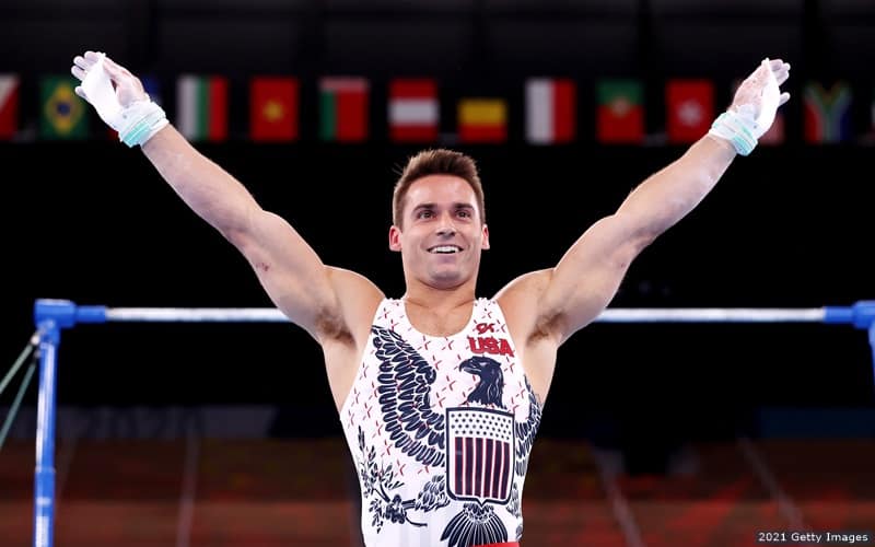 U.S. gymnast Sam Mikulak holds his arms out and smiles after competing in the horizontal bar at the Tokyo 2020 Olympic Games.