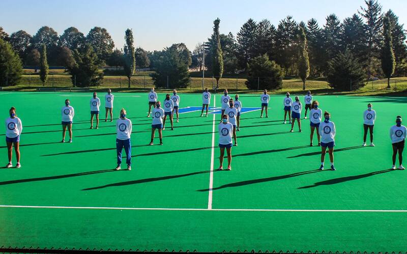 Hofstra field hockey team stands in solidarity on the pitch to support No Locker for Racism