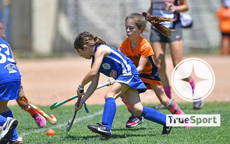 Youth field hockey athletes with TrueSport Logo