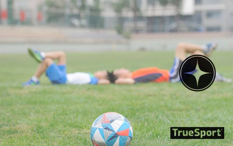 Soccer players laying on field