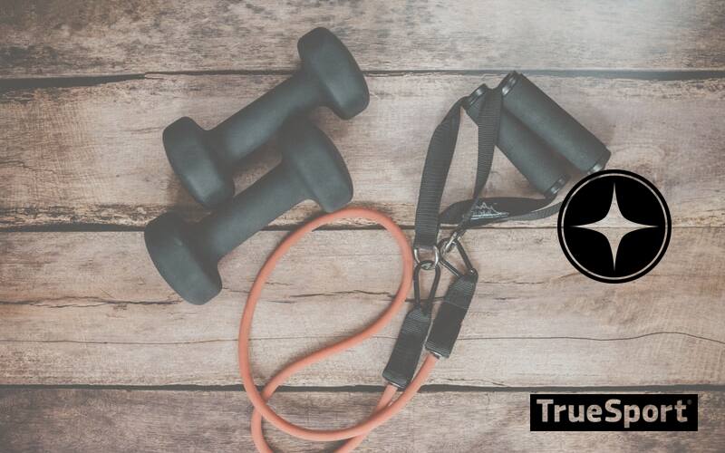 Black 5 pound Weights and resistance bands on Wooden Floor