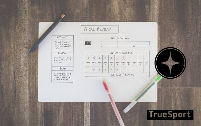 Goal Calendar on Wooden Desk with Multi-Color Pens