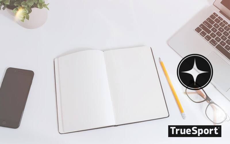 Empty Notebook next to laptop and pen