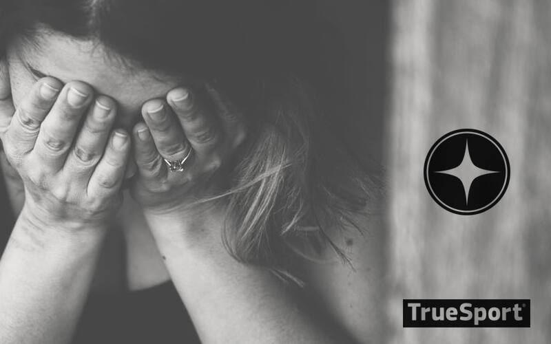 Woman with head in hands.