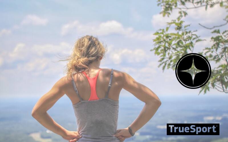 Woman with hand on hips with clouded sky in the background 