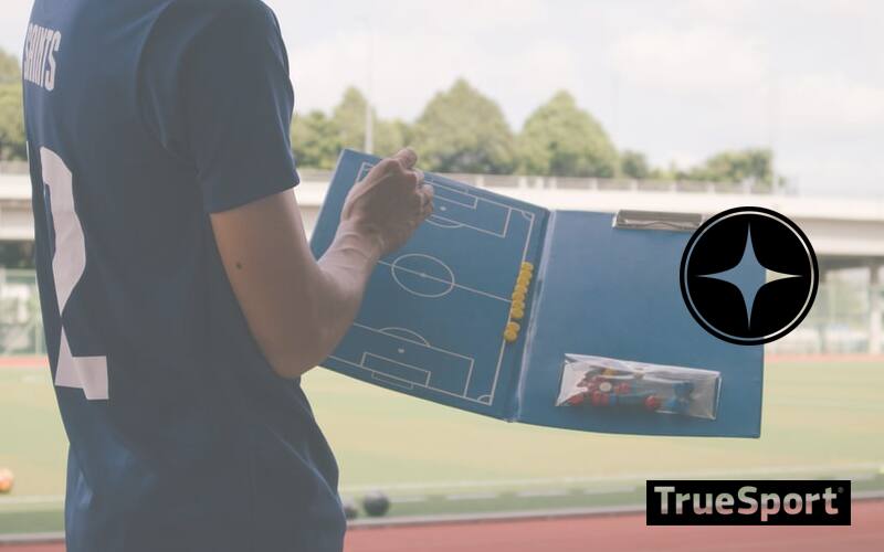Coach on sidelines with clipboard