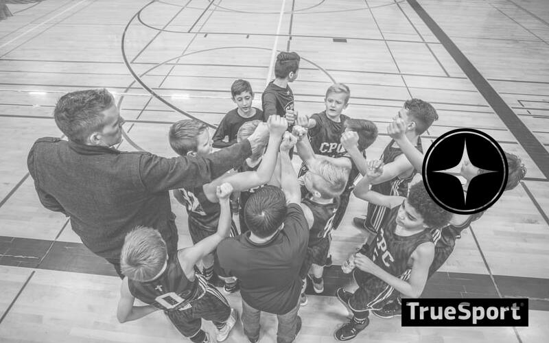 Greyscale Basketball Athletes and Coach in Huddle in the Gymnasium 