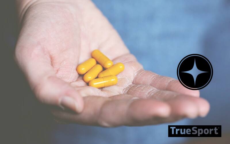 Hand holding yellow pills