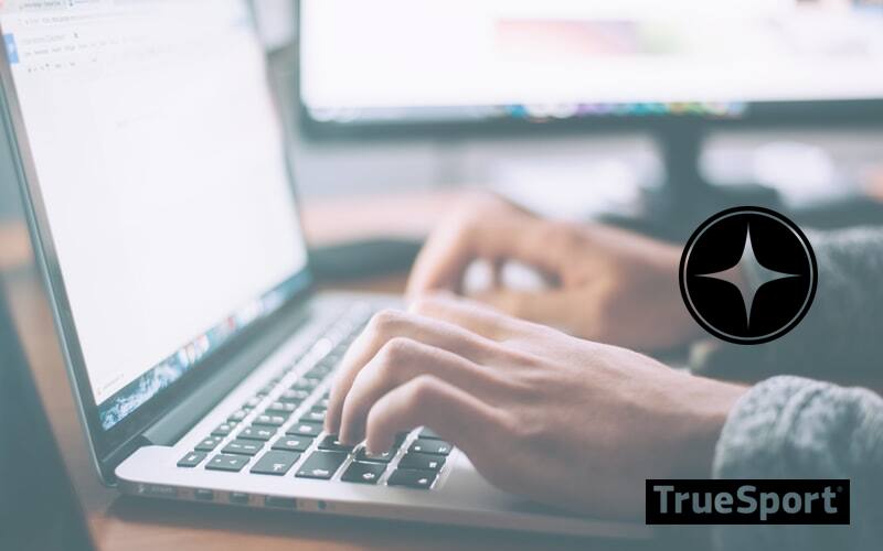 Laptop open with bright white screen and hands typing