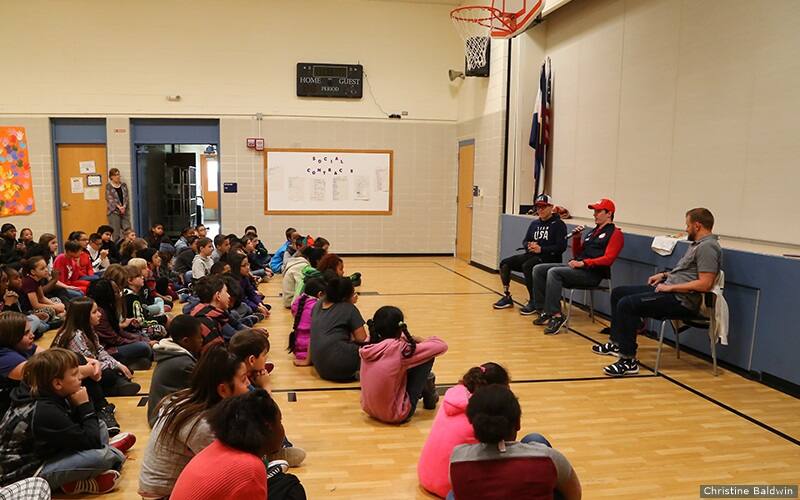 Jason Macom, Ryan Boyle and Justin Widhalm speak to students at John Adams Elementary School.