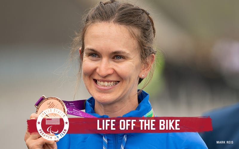 Sam Bosco of road and track cycling holds up her bronze medal