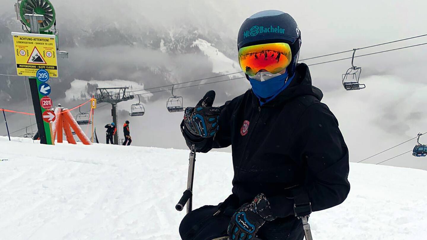 Ravi Drugan smiles for camera in front of slopes. 