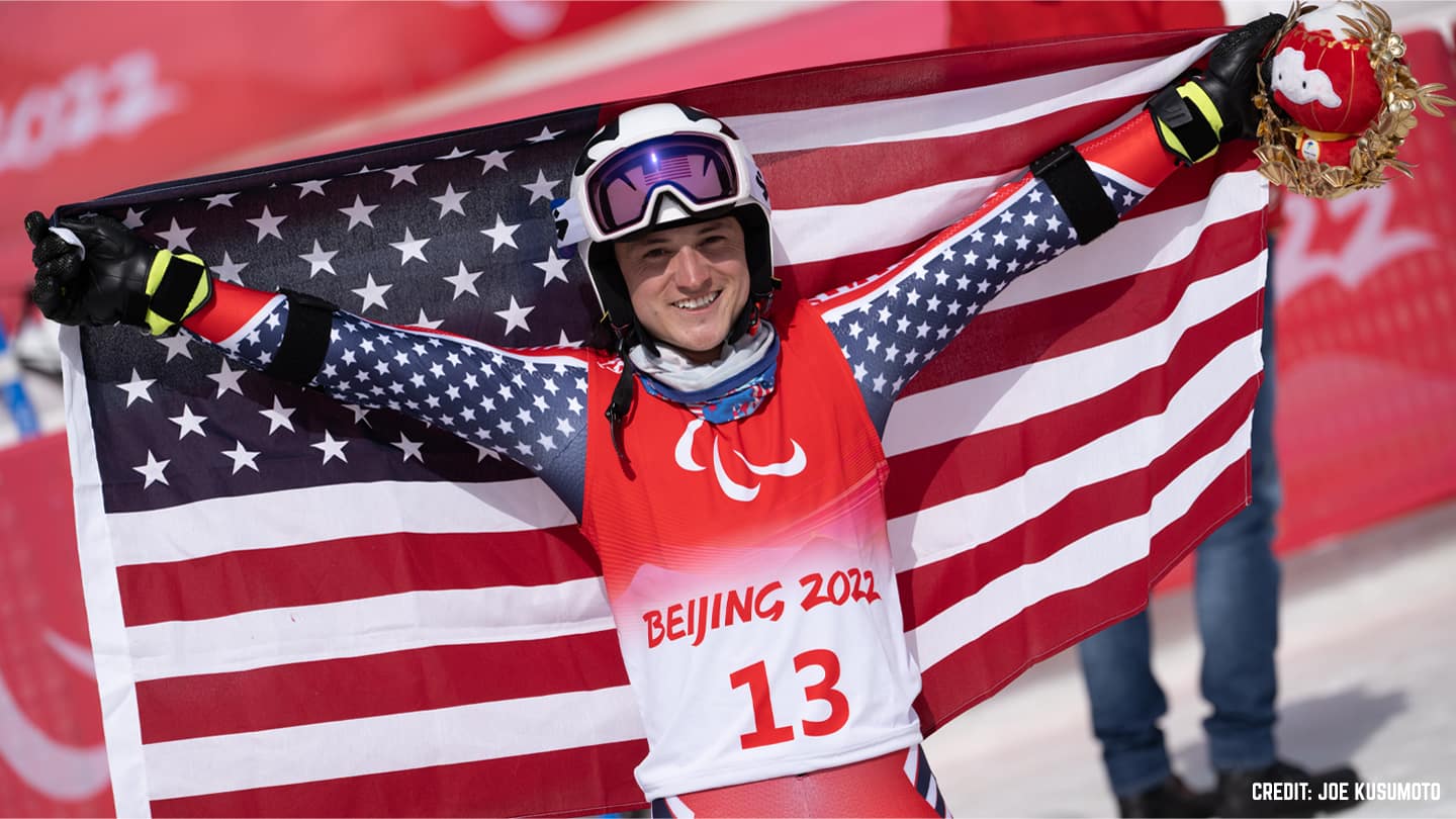 Thomas Walsh smiles to camera and holds up US flag after winning Giant Slalom silver