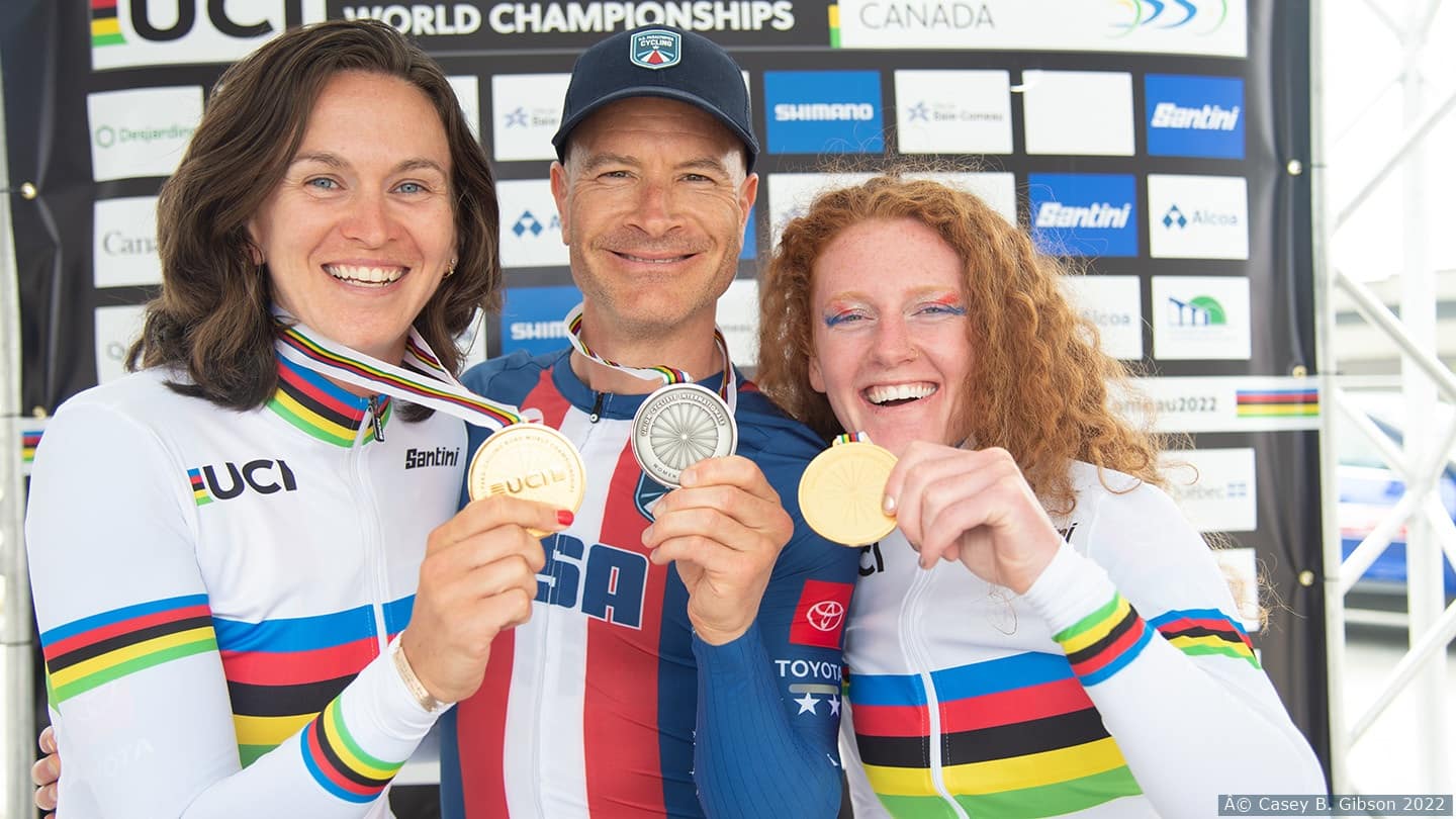 Sam Bosco, Aaron Keith and Clara Brown hold up championships medals. 