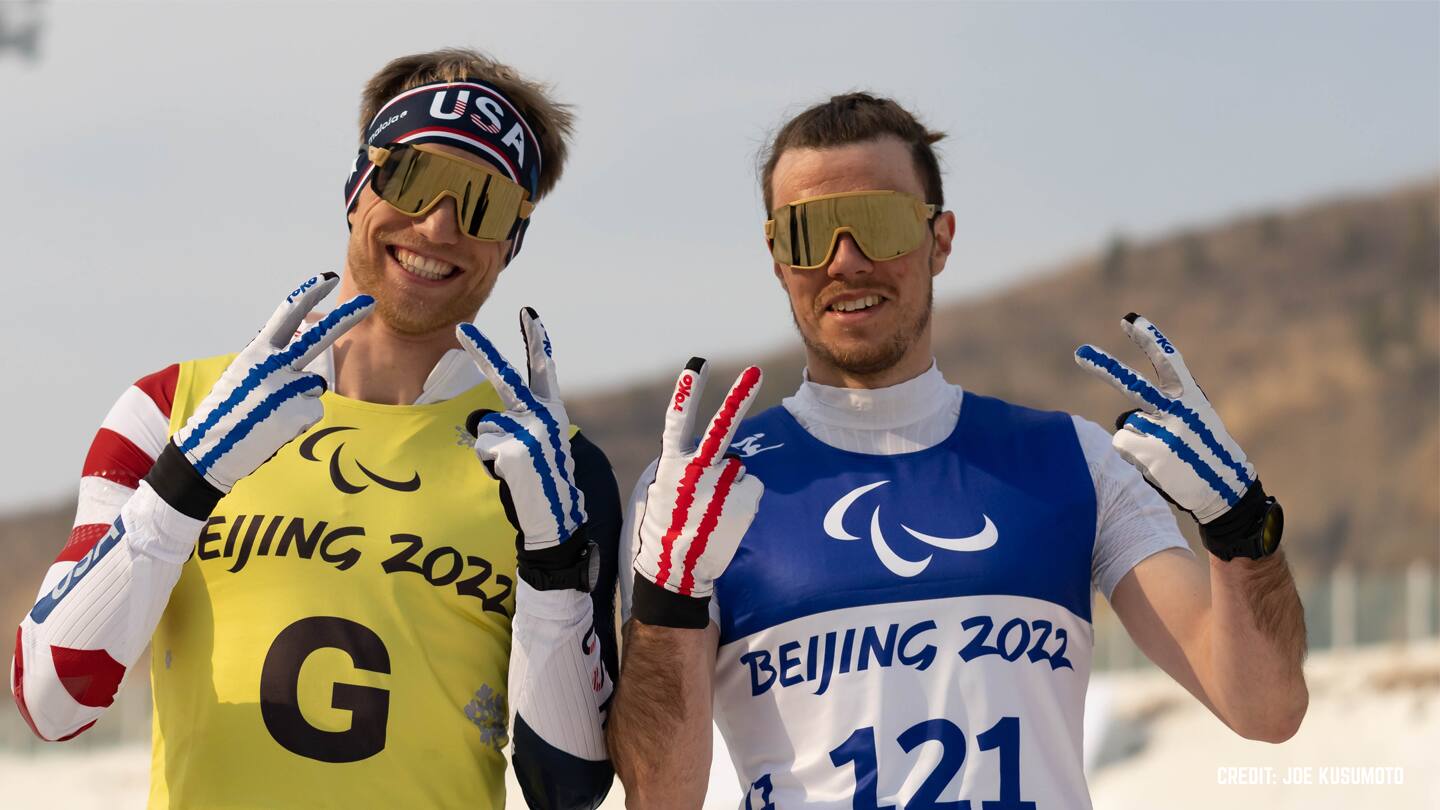 Jake Adicoff and Sam Wood smile to the camera after racing at the 2022 Paralympic Games. 