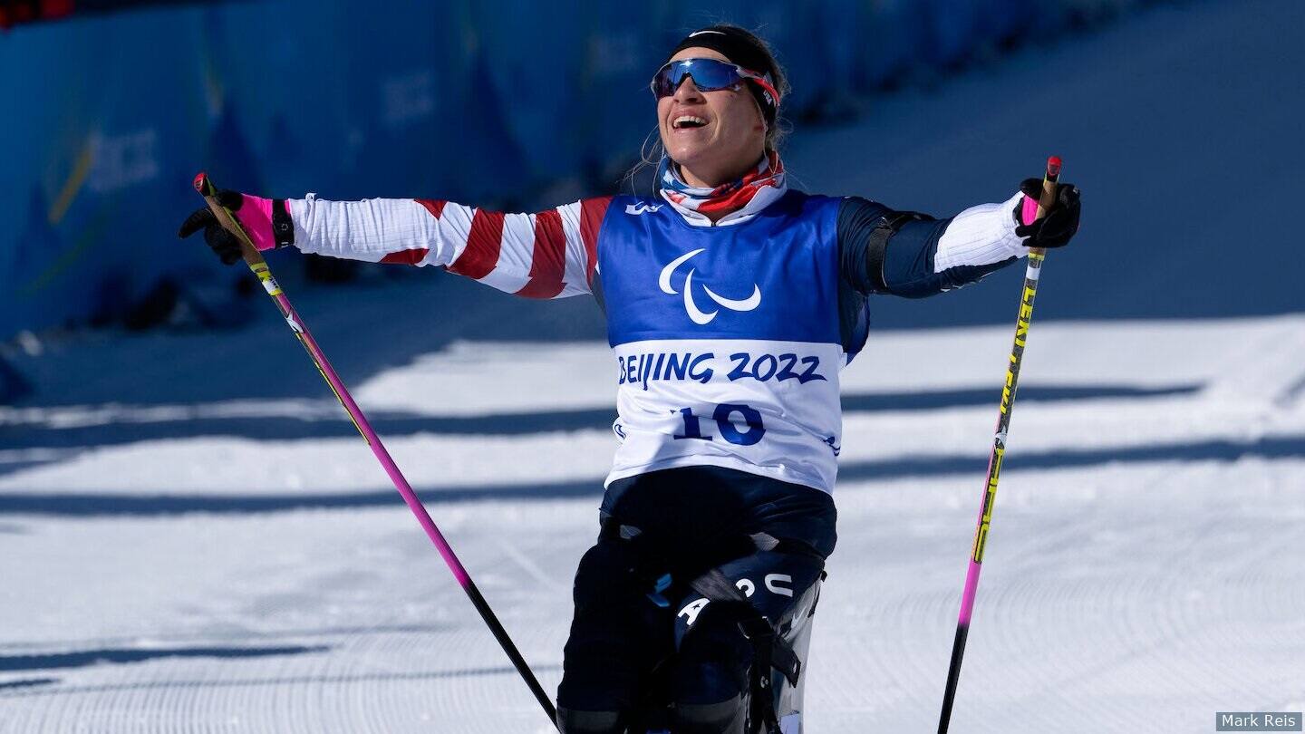 Oksana Masters smiles in finish line after winning sprint biathlon gold. 