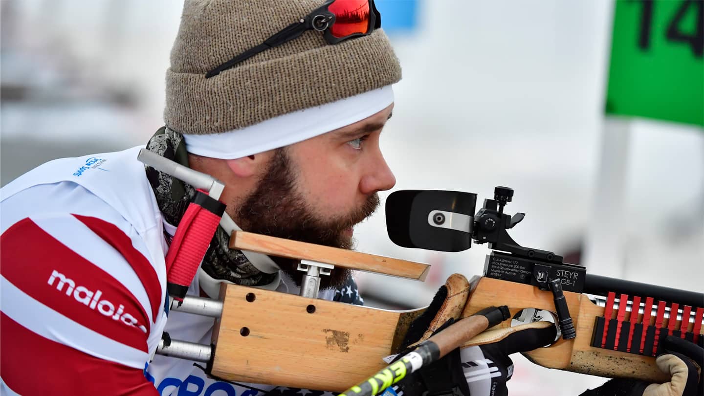 Aaron Pike aims at the shooting target in a Biathlon competition