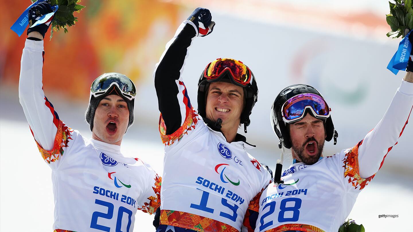 Evan Strong (C) celebrates winning the gold medal with silver medalist Michael Shea (L) and bronze medalist Keith Gabel during the flower ceremony for the Men's Para Snowboard Cross Standing on day seven of the Paralympic Winter Games Sochi 2014 at Rosa Khutor Alpine Center on March 14, 2014 in Sochi, Russia.