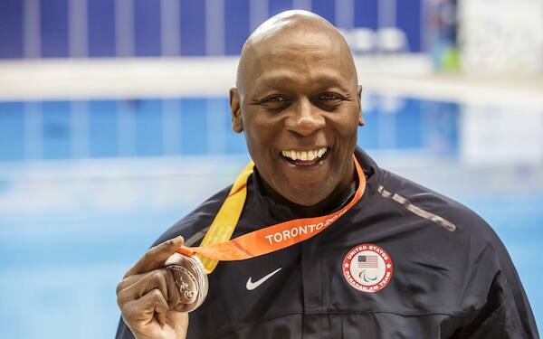 Curtis Lovejoy holds up his Paralympic medal