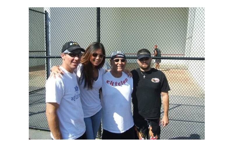 Four people standing outside at a tournament.