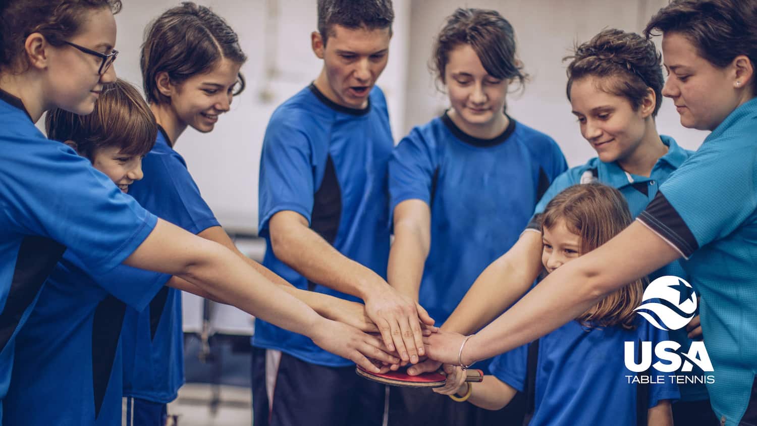 Table Tennis Club team with hands in.
