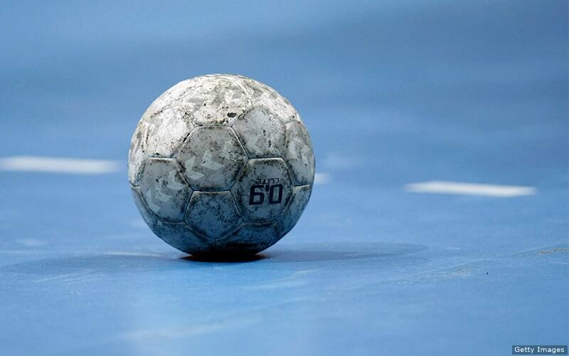 A handball rests on the court.