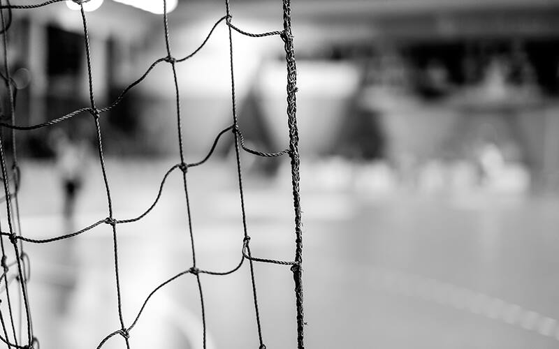 Black and white shot of a handball goal and net