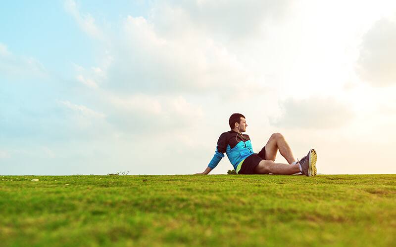 runner sitting on grass