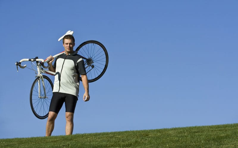 Cyclist holding bike with confident posture