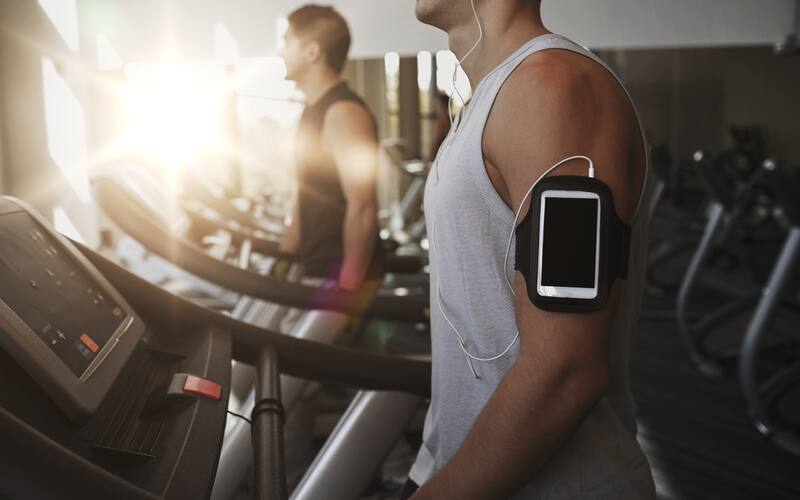 man on treadmill with armband and headphones
