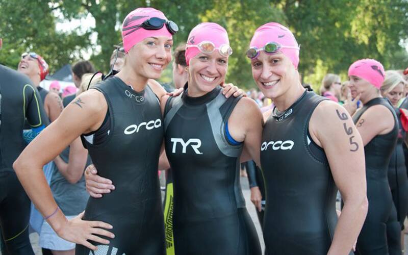 three tri moms smiling before the swim