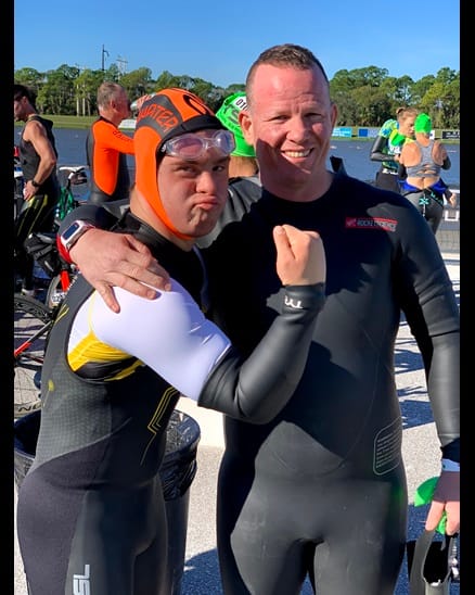 chris posing with coach in wetsuit