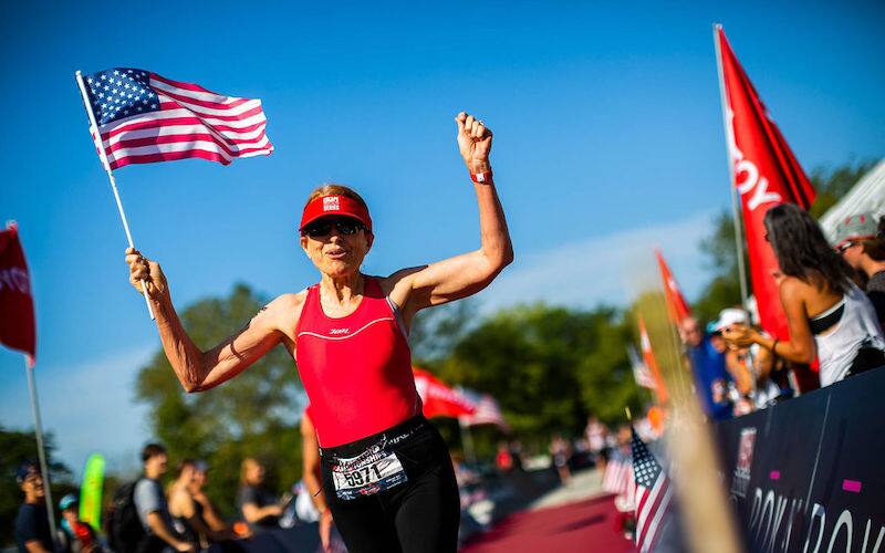 happily crossing finish with flag