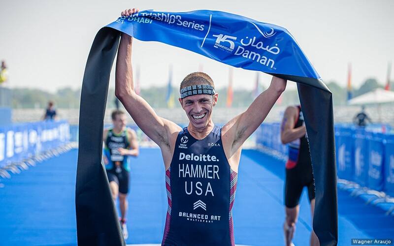 chris hammer holds the finish line tape above his head after winning world championship