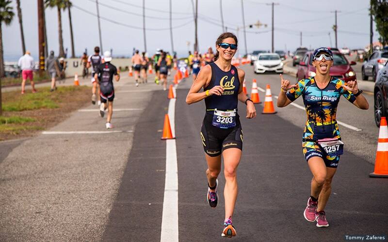 two smiling triathletes run the course at Collegiate Club Nationals in Malibu, California