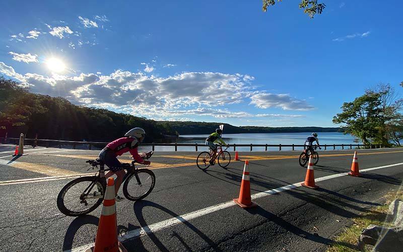 Athletes cycle along beach front in stony point new york