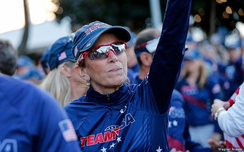 woman wearing red white and blue team usa gear walks in the athlete parade at triathlon world championships.