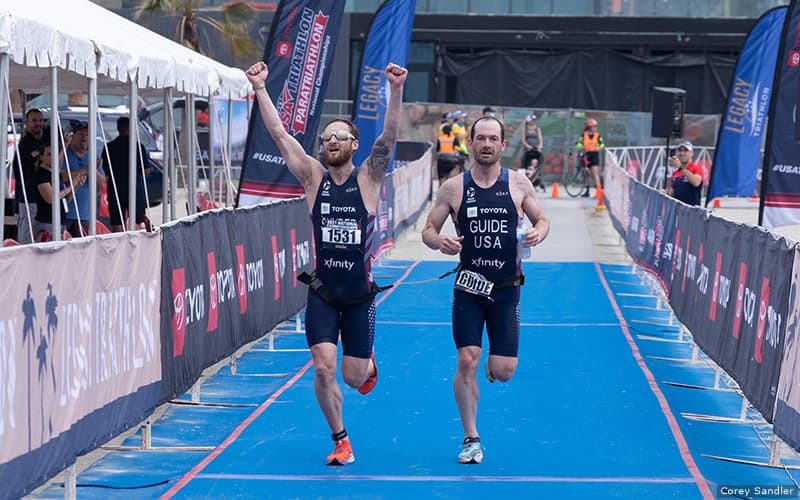 Elite paratriathlete Brad Snyder runs with his guide Greg Billington toward the finish line at the Toyota Paratriathlon National Championships in 2021.