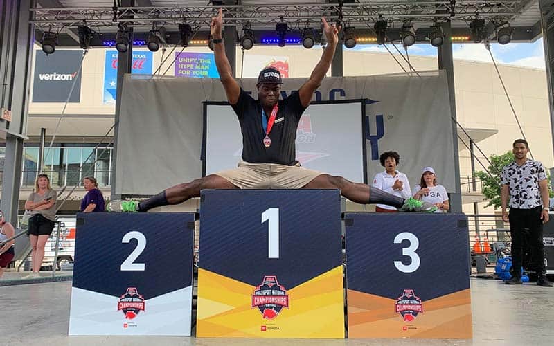 Kevin Gaston does the splits on the podium in Texas at the Multisport Festival